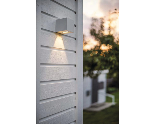 Fyrkantig utomhusvägglampa på en trävägg med ljusstråle