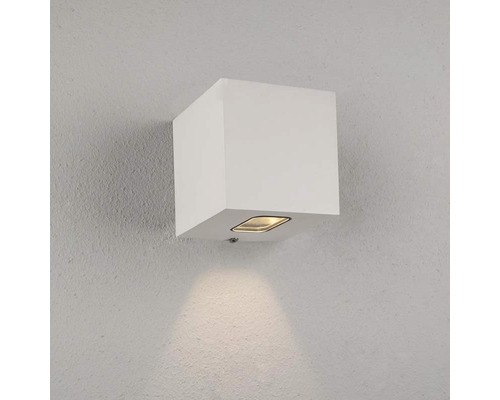 Fyrkantig vit vägglampa monterad på en vägg.