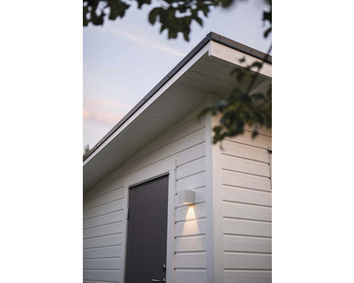 Trädgårdshus i trä med grå dörr och fyrkantig vägglampa