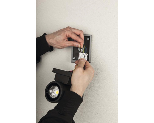 Installation av en svart vägglampa med LED-lampa