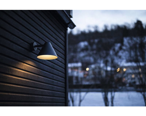 En yttervägglampa på en trävägg med kvällsutsikt utomhus.