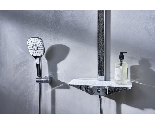 Duschpelare med handdusch och hylla med dispenserflaska i badrummet