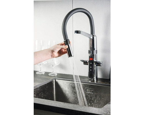 Köksblandare med utdragbar dusch över en diskho med rinnande vatten