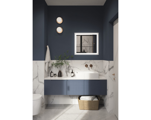 Badrum med handfat, spegel med belysning, handduk och dekoration