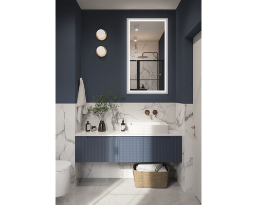 Modernt badrum med tvättställ, spegel med belysning och dekoration