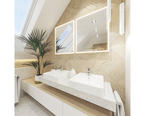 Ljust badrum med dubbla handfat, belysta speglar och krukväxt