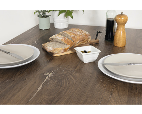 Matbord med bröd, oliver, tallrikar och bestick