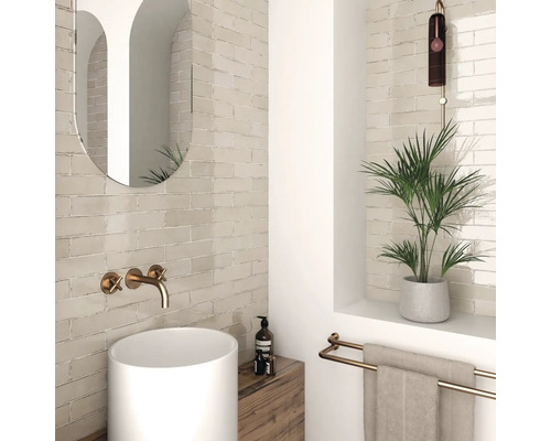 Ljust badrum med handfat, spegel, kran, handdukshållare och växter