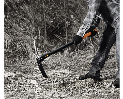 Person som arbetar med en hacka för att bearbeta jorden.