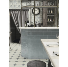 Interiörbild av ett kafé med kaklad bardisk, bord och stolar