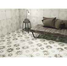 Rumsöversikt med golvplattor och väggplattor i blomdesign, kompletterat med en sittbänk, en pall och en lampa