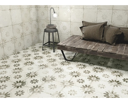 Rumsöversikt med golvplattor och väggplattor i blomdesign, kompletterat med en sittbänk, en pall och en lampa