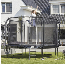 Rektangulär trädgårdstrampolin med säkerhetsnät och stege, med en flicka som hoppar på den.
