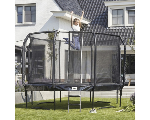 Rektangulär trädgårdstrampolin med säkerhetsnät och stege, med ett bostadshus i bakgrunden.