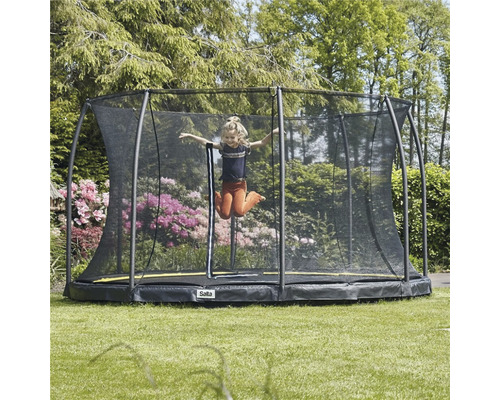 Flicka hoppar på trädgårdstrampolin med säkerhetsnät från Salta