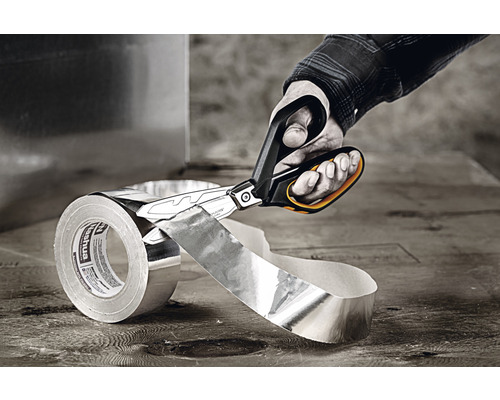 En hand skär av en bit aluminiumtejp med en plåtsax.