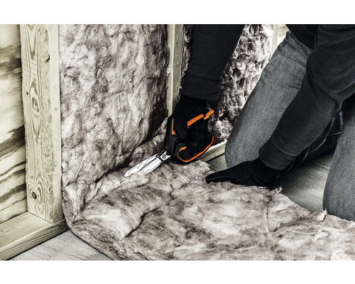 Skära isoleringsull med sax för väggisolering