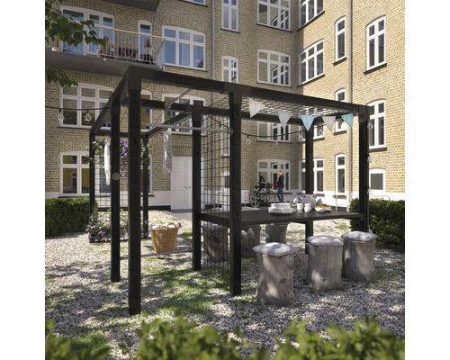 Pergola med bord, trädstamspallar och dekoration i trädgården