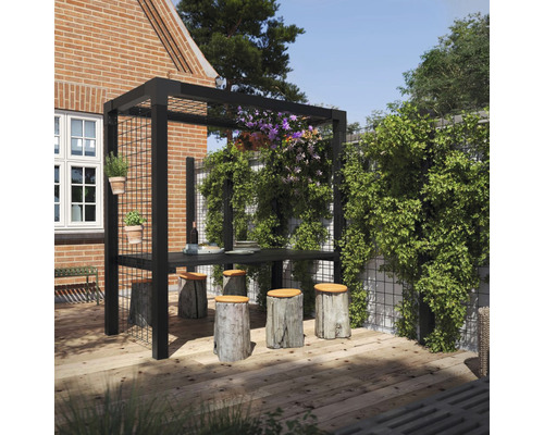 Trädgårdsscen med svart pergola, träbord och pallar av trädstammar på en träterrass.