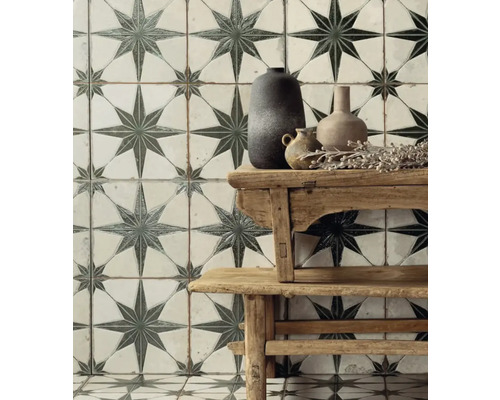 Vägg- och golvplattor med stjärnmönster bakom ett träbord med vaser