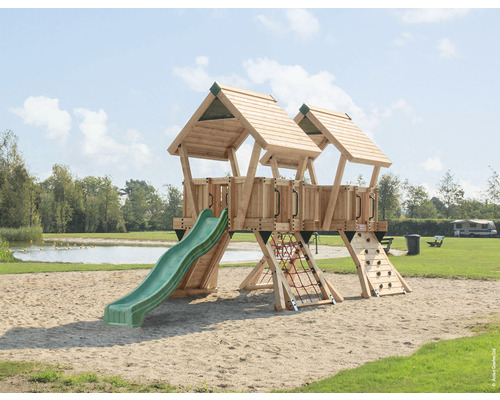 Lekplats med rutschkana, klättervägg och klätternät på en sandplan