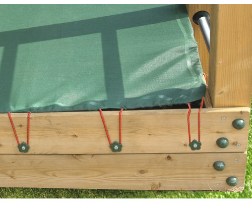 Detaljvy av ett sandlådeskydd med gummiband på en träram