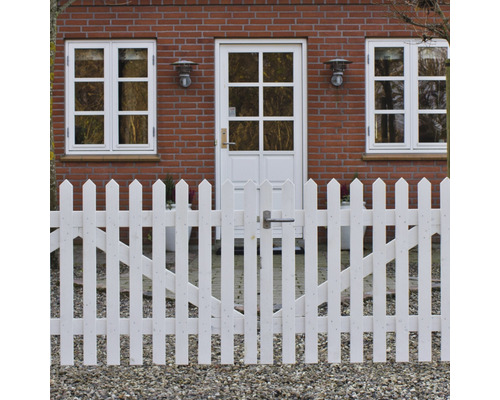 Vitt trästaket med trädgårdsport framför ett tegelhus