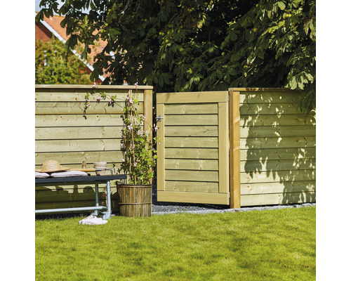 Trädgårdsscen med trästaket och trädgårdsport