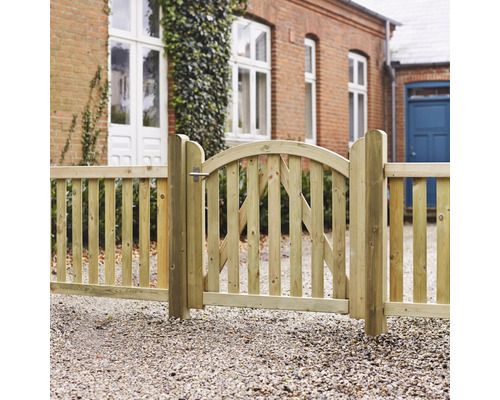 Trästaket med grind framför tegelhus