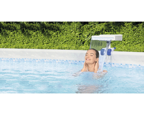 Kvinna kopplar av i poolen under ett vattenfall