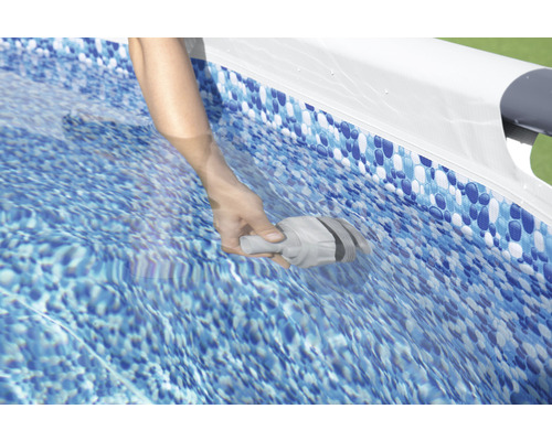 En hand håller ett poolrengöringstillbehör i vattnet i en pool.