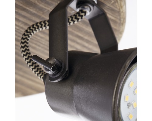 Detaljbild av en taklampa med justerbar spotlight och textilsladd