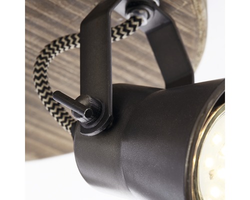 Detaljbild av en svart taklampa med textilsladd