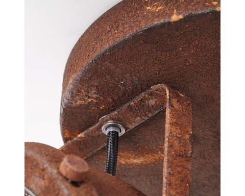 Detaljvy av en taklampa i rostdesign med kabel