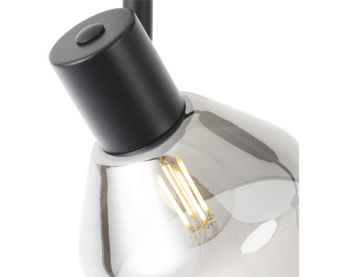 Detaljbild av en pendellampa med ljuskälla och grått glasskydd