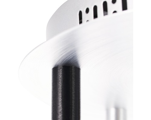 Detaljbild av en silverfärgad lampskärm med svart upphängning