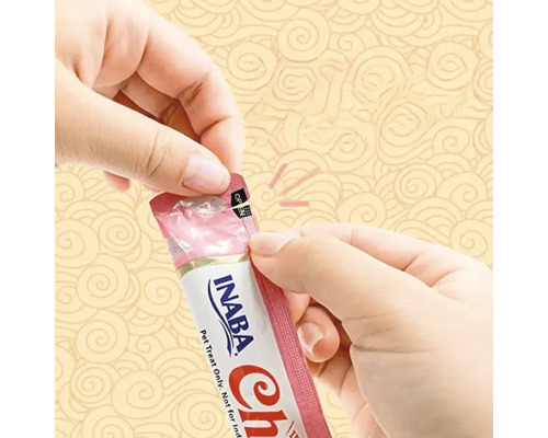 En person öppnar en Inaba Churu kattgodisförpackning.