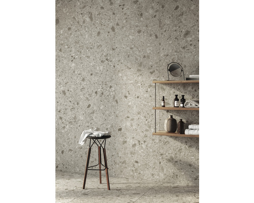 Badrum med vägg- och golvplattor i terrazzolook, hylla och pall