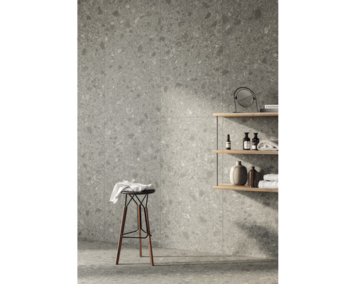 Badrum med gråmönstrade plattor, pall och hylla