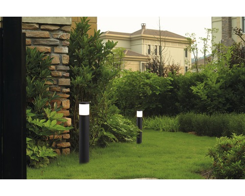 Två trädgårdslampor på en gräsmatta