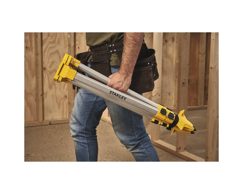 En person bär ett Stanley-stativ.