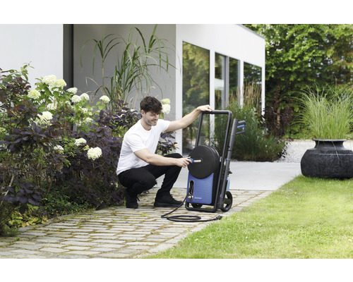 Man förbereder högtryckstvätt i trädgården