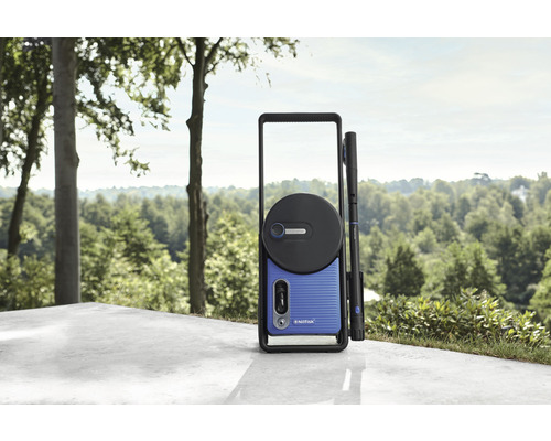 Nilfisk högtryckstvätt på en terrass med träd i bakgrunden.