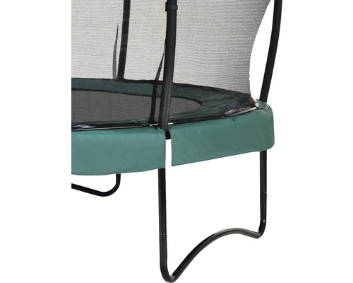 Detaljvy av en trädgårdstrampolin med säkerhetsnät och grönt kantskydd