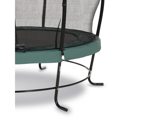 Detaljvy av en trädgårdstrampolin med säkerhetsnät och grönt kantskydd