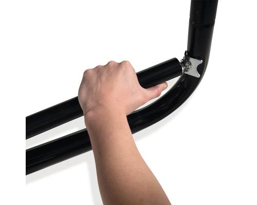 Närbild av en hand som fäster ett svart metallrör på ett fäste