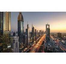 Panoramabild av Dubai med skyskrapor och vägar i solnedgången.