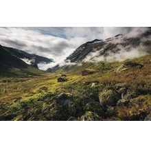 Landskap med berg, moln och stugor med grästak