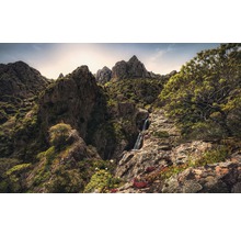 Landskap med bergmassiv, vattenfall och vegetation