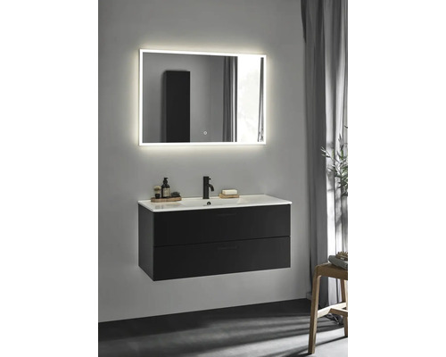 Modernt badrum med svart tvättställsskåp, vitt handfat och belyst spegel